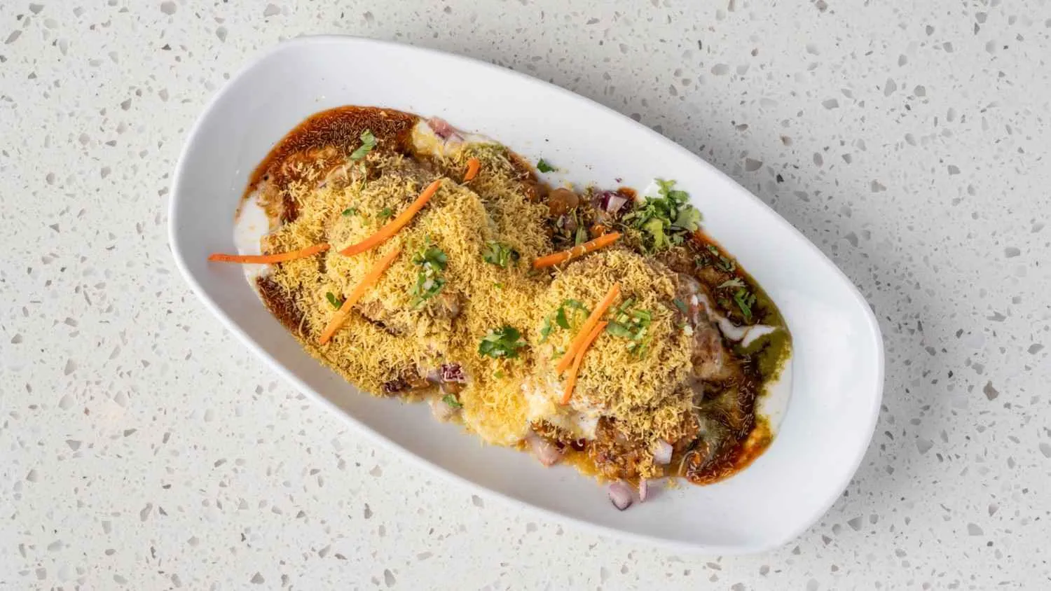 Aloo tikka samosa chaat with yogurt and tamarind chutney